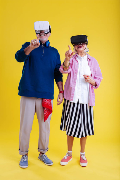 Stylish retired couple feeling involved in studying virtual reality - 写真・画像