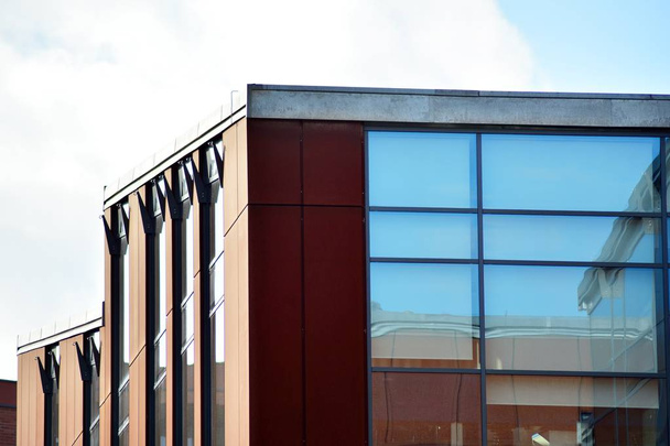 Небо отражается в современном стеклянном фасаде здания
 - Фото, изображение