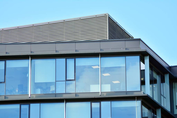 Небо отражается в современном стеклянном фасаде здания
 - Фото, изображение