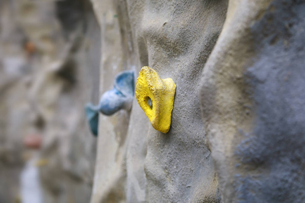 Parete di arrampicata artificiale con impugnatura gialla
 - Foto, immagini