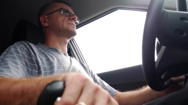 Senior man rijdt een auto op de snelweg. Man zijn auto rijden op vakantie. 4k - Video