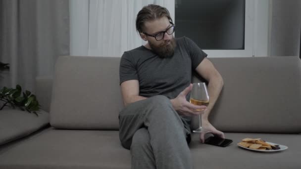 Handsome bearded man relaxing on sofa - Filmati, video
