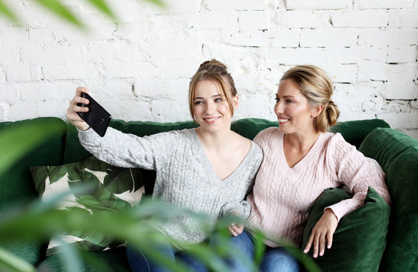 mature mother and her daughter making a selfie using smart phone    - 写真・画像