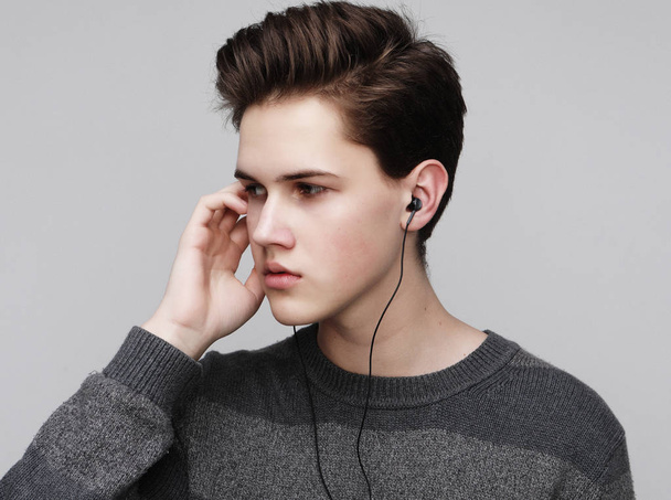 Modern teenage boy enjoys the music in headphones - Zdjęcie, obraz