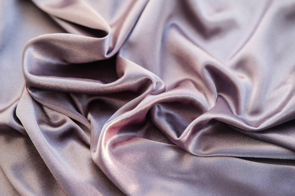 крупним планом рожева тканина. Фіолетова срібна тканина викладена хвилями
 - Фото, зображення