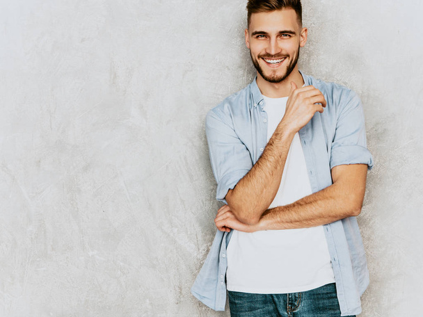 Portrait of handsome smiling hipster lumbersexual businessman model wearing casual shirt clothes. Fashion stylish man posing against gray wall - Φωτογραφία, εικόνα