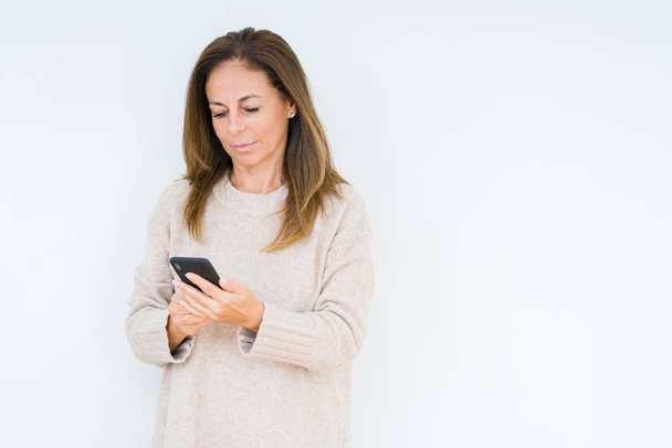 Middle age woman using smartphone over isolated background with a confident expression on smart face thinking serious - Φωτογραφία, εικόνα