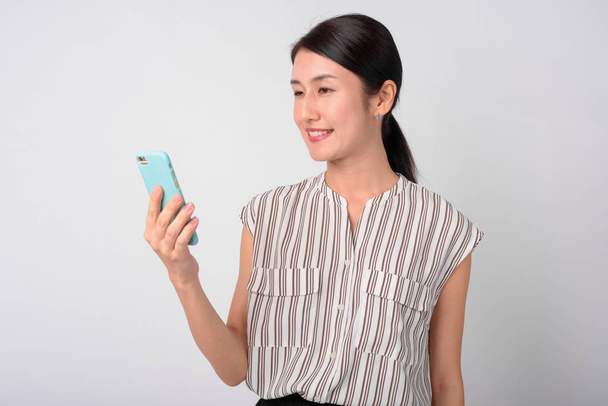 Portrait of happy Japanese businesswoman using phone - Φωτογραφία, εικόνα