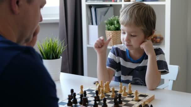 Little boy playing chess with his father. Education and family concept - Video