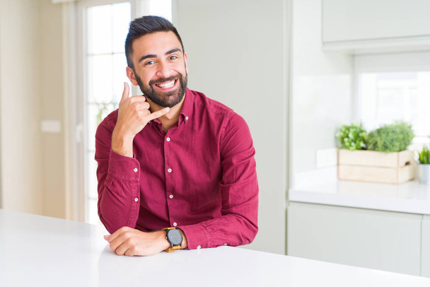 Красивий іспаномовний бізнесмен посміхається робити телефонний жест рукою і пальцями, як розмовляти по телефону. комунікаційні концепції
. - Фото, зображення