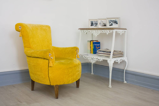 Wit interieur met een retro geel fauteuil - Foto, afbeelding