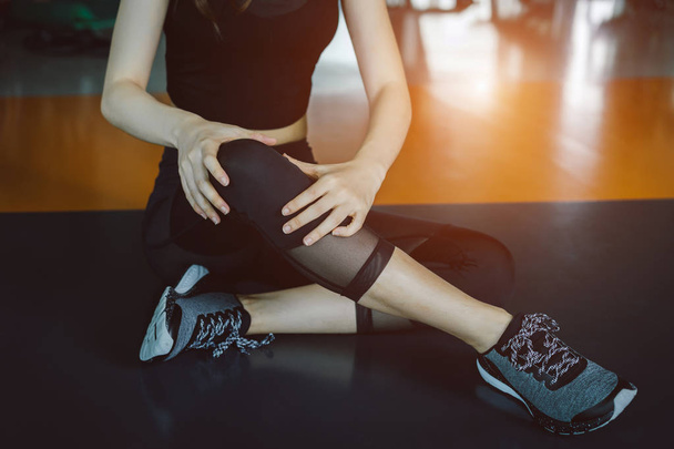 Žena, která dělá sportovní cvičení poranění kolena havárie v posilovně fitness  - Fotografie, Obrázek