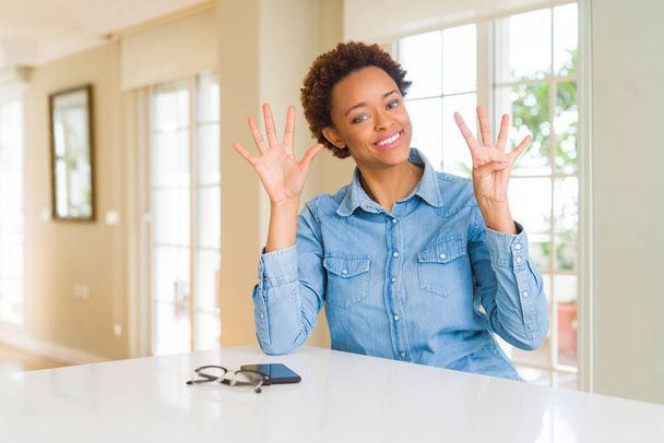 Jonge mooie Afrikaanse Amerikaanse vrouw tonen en met vingers omhoog nummer negen terwijl lacht zelfverzekerd en blij. - Foto, afbeelding
