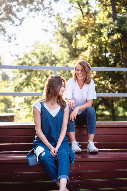 Two beautiful young woman resting on a bench - Fotografie, Obrázek