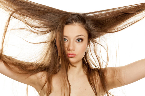 Jovem loira mostrando seu longo cabelo liso em um fundo branco
 - Foto, Imagem