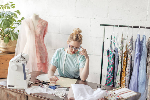 Fashion designer at work. Talanted dressmaker drawing sketch at her workspace - Foto, Bild