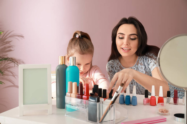 Cute daughter with mother making manicure at home - Photo, Image
