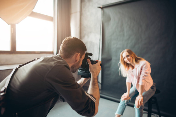 charming girl in fashion jeans and pink jacket taking part in a photo session - 写真・画像