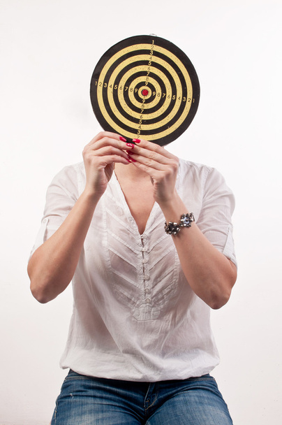 Young woman with dartboard in front of face, Bull's Eye - Foto, Imagen
