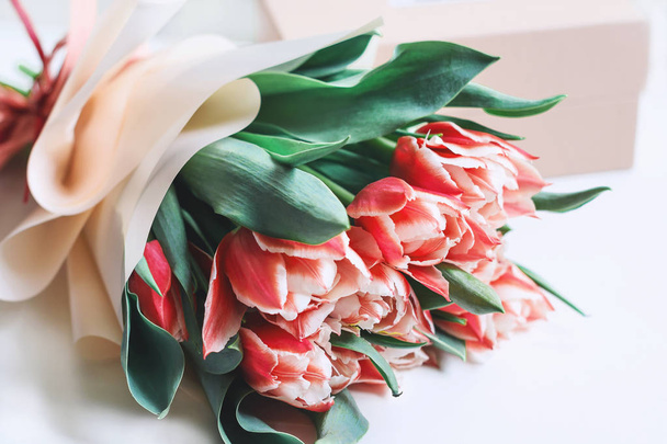 A bunch of pink tulips on white background with a gift box. Spring concept. Greeting card with flowers. - Photo, Image
