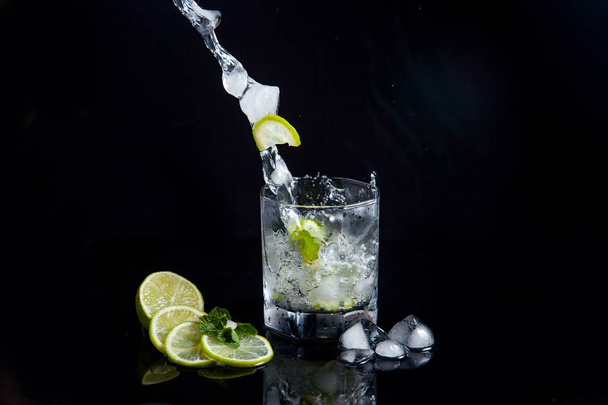 Summer cocktail mojito with splash on black background - Foto, afbeelding