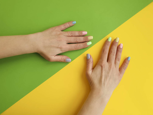 female hands manicure on color paper background - Foto, afbeelding