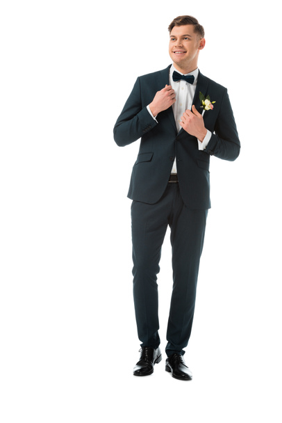 happy bridegroom in elegant black suit with boutonniere isolated on white - Zdjęcie, obraz