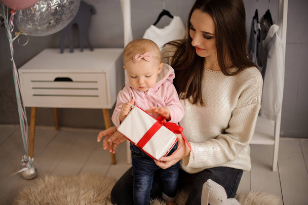 Woman and her cute little daughter holding a present - Foto, immagini