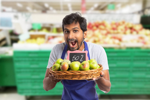 Чоловік працює в гіпермаркеті з продажу реклами в яблуці
 - Фото, зображення