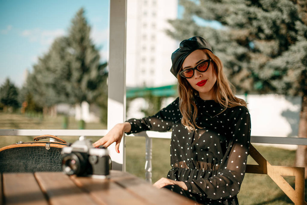 Mooie jongedame in een vintage polka-dot jurk in een retro-stijl fotoshoot - Foto, afbeelding