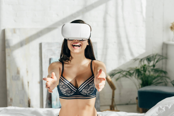 mulher morena feliz em roupa interior usando fone de ouvido realidade virtual
  - Foto, Imagem