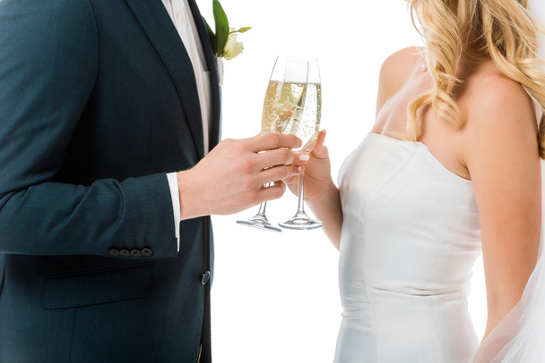 cropped view of bride and groom clinking glasses of champagne isolated on white - Foto, imagen
