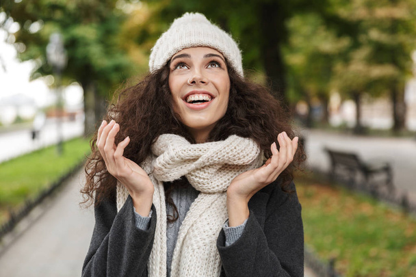 Portrait closeup of pleased woman 20s wearing hat and scarf, smi - Zdjęcie, obraz