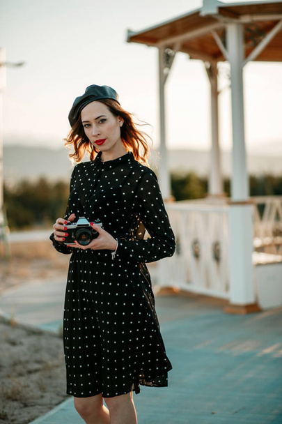 Mooie jongedame in een vintage polka-dot jurk in een retro-stijl fotoshoot - Foto, afbeelding