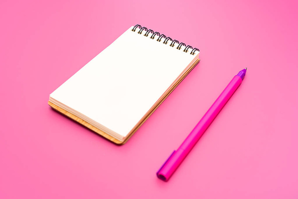 Blank notebook with spiral for the application of labels and pen on pink background - Photo, Image