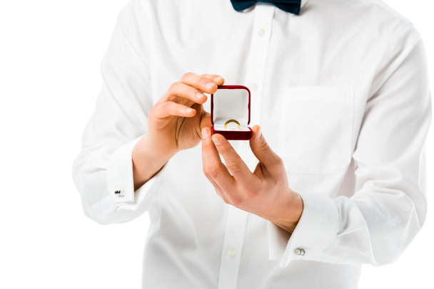 selective focus of groom showing gift box with wedding ring isolated on white - Foto, imagen