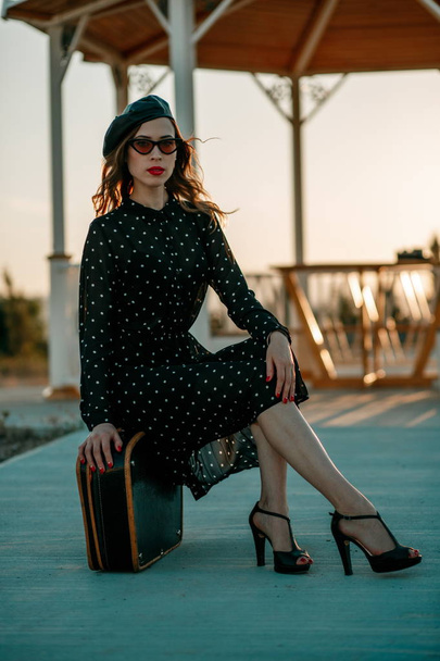 Young beautiful woman in a vintage polka-dot dress in a retro-style photo shoot - Zdjęcie, obraz