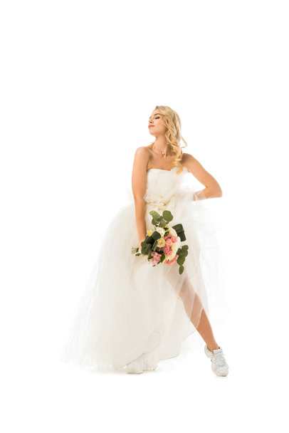 ウェディング ドレスと白で隔離のスニーカーでポーズ美しい若い女性 - 写真・画像