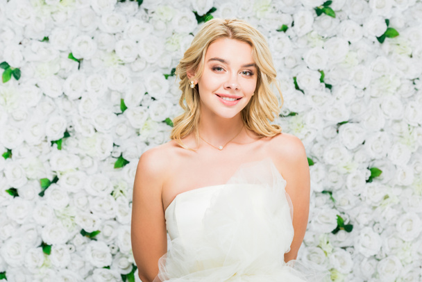 beautiful young woman with blonde hair on white floral background - Φωτογραφία, εικόνα