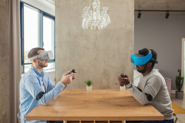 Deux hommes divers en tenue décontractée développent un projet en utilisant des lunettes de réalité virtuelle
. - Photo, image