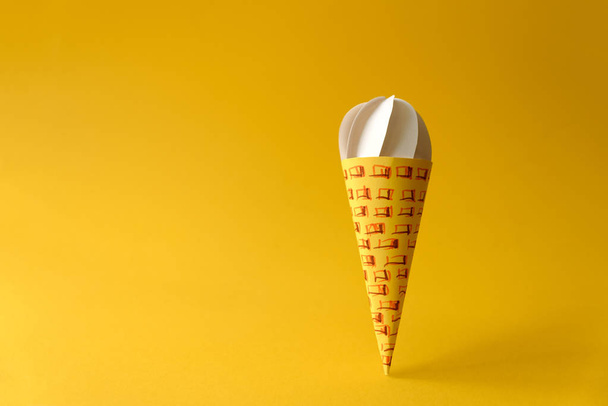 Paper vanilla ice-cream cone on yellow background. Copy space. Creative or art food concept - Photo, Image