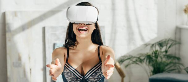 仮想現実のヘッドセットを着ている下着で幸せなブルネット女のパノラマ撮影  - 写真・画像