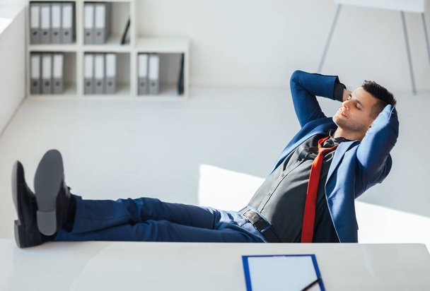 Businessman relaxing in office with legs on the table.  Success and relax concept  - Zdjęcie, obraz