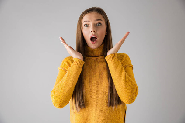 Shocked excited young woman isolated over grey wall background. - Φωτογραφία, εικόνα