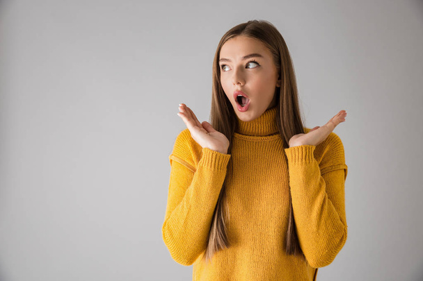 Shocked excited young woman isolated over grey wall background. - Zdjęcie, obraz