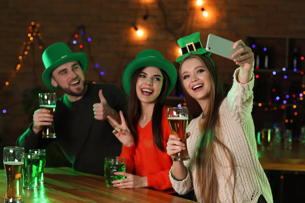 Młodych ludzi obchodzi St Patrick's Day w pubie - Zdjęcie, obraz