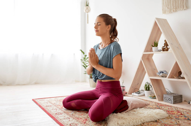 woman meditating in lotus pose at yoga studio - Foto, Imagem