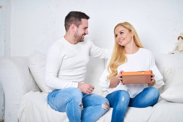 Couple on a sofa giving presents - Foto, Bild