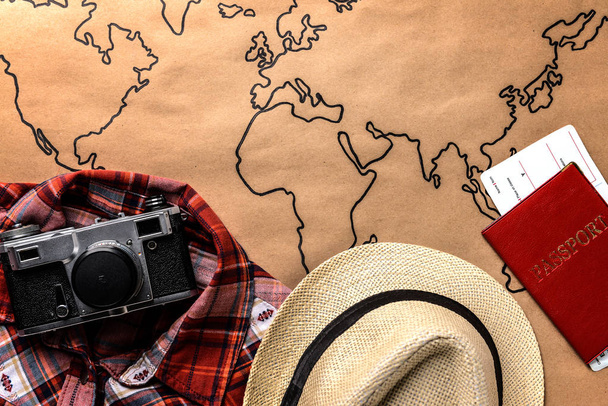 Ρούχα, φωτογραφική μηχανή φωτογραφιών, διαβατήριο και εισιτήρια σε παγκόσμιο χάρτη. Έννοια του ταξιδιού - Φωτογραφία, εικόνα