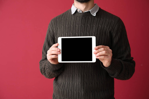 Молодой бизнесмен с планшетным ПК на цветном фоне
 - Фото, изображение